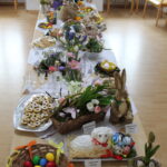 Stůl plný velikonočních dekorací a pokrmů.